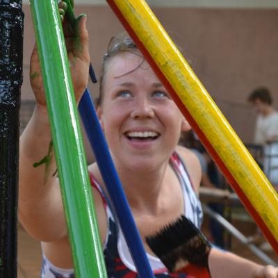 A construction volunteer in Ghana painting a playground structure. A Projects Abroad construction volunteer in Ghana painting a playground.